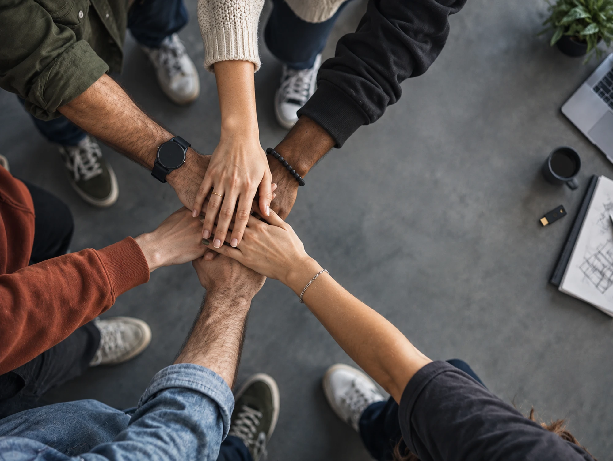 A team stacking their hands together in a circle